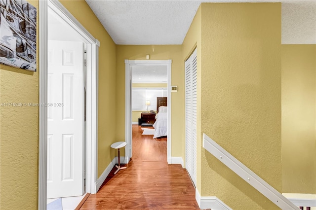 hall featuring hardwood / wood-style flooring and a textured ceiling