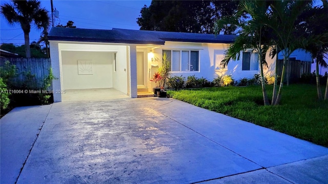 single story home with a garage and a front lawn