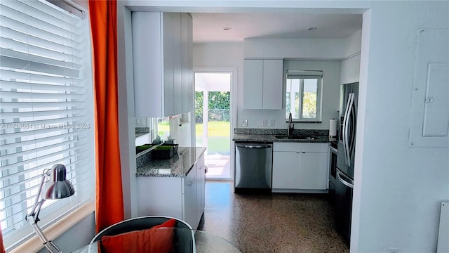 kitchen featuring white cabinets, dark stone countertops, sink, and appliances with stainless steel finishes