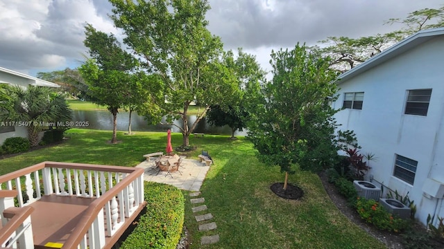 view of yard with a patio area, a water view, and cooling unit