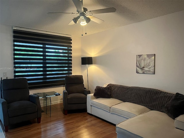 living room with wood-type flooring, a textured ceiling, and ceiling fan