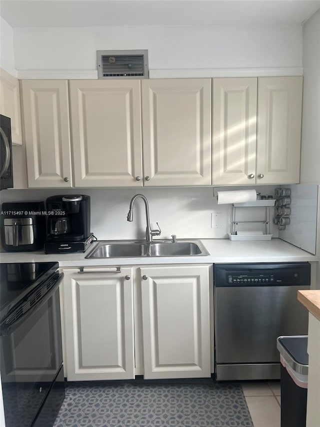 kitchen with black appliances, white cabinets, sink, and tile patterned floors