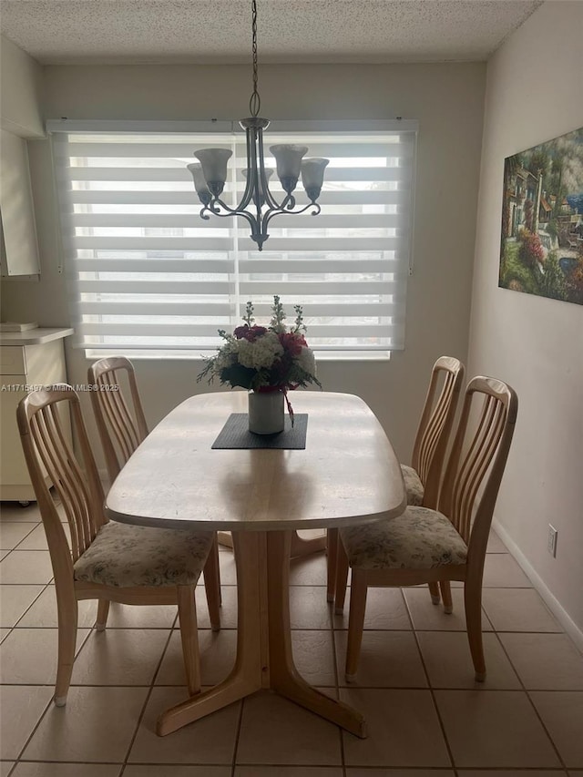 dining space with a notable chandelier, light tile patterned floors, and a textured ceiling