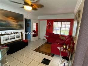 living room with light tile patterned floors, ornamental molding, and ceiling fan