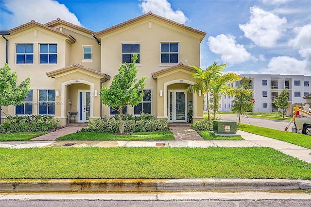 mediterranean / spanish house with a front lawn