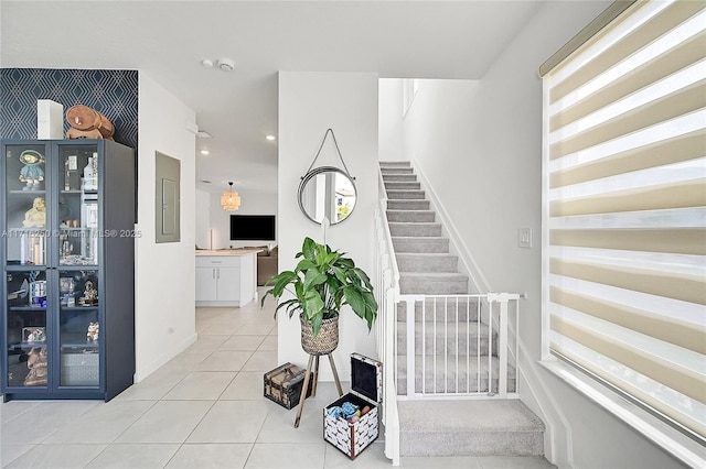 staircase with tile patterned flooring and electric panel