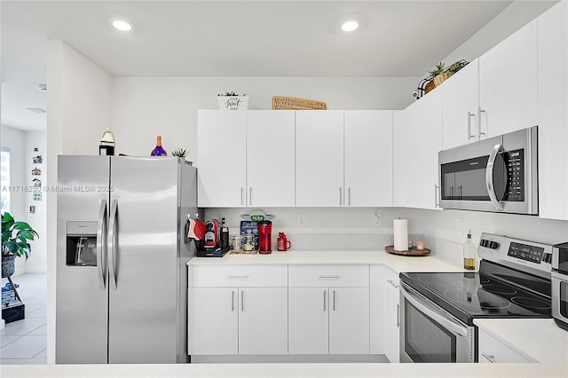 kitchen with light tile patterned floors, white cabinetry, and appliances with stainless steel finishes