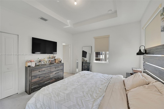 carpeted bedroom featuring a tray ceiling