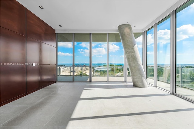 interior space featuring a water view, plenty of natural light, and floor to ceiling windows