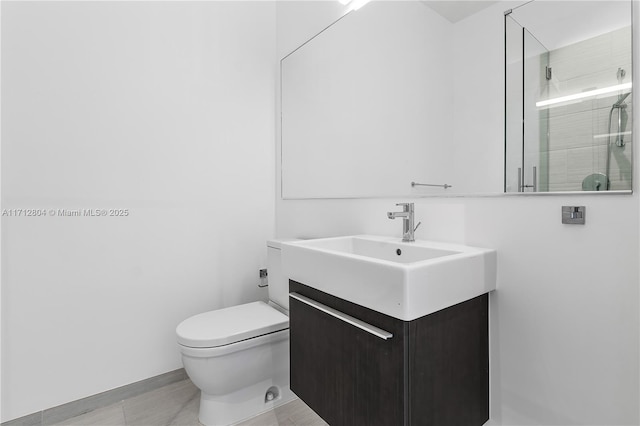 bathroom featuring a shower with door, vanity, and toilet