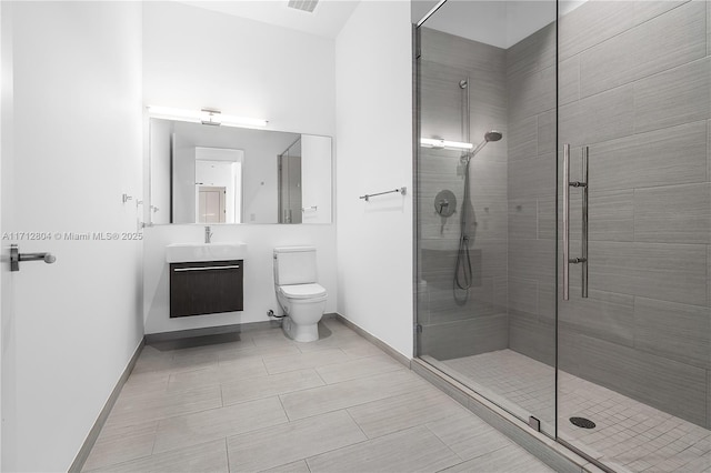 bathroom with tile patterned floors, vanity, toilet, and a shower with shower door