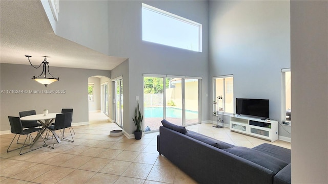 tiled living room featuring a towering ceiling and a textured ceiling