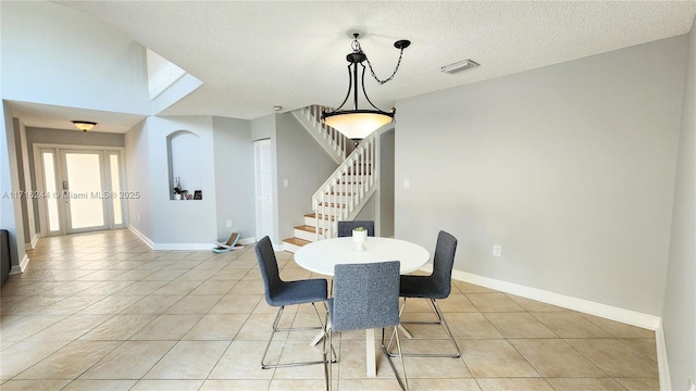 tiled dining room with a textured ceiling