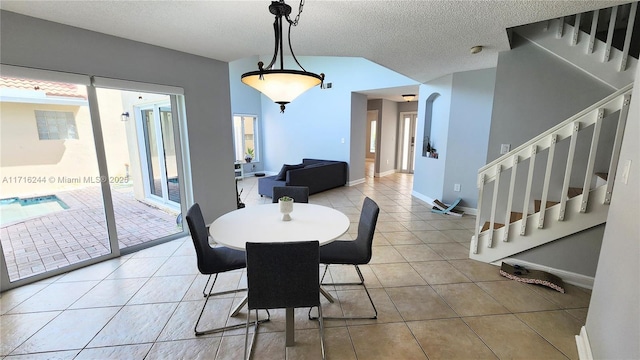 tiled dining area featuring a textured ceiling