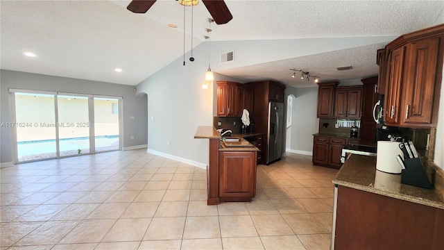 kitchen with decorative backsplash, appliances with stainless steel finishes, ceiling fan, sink, and lofted ceiling