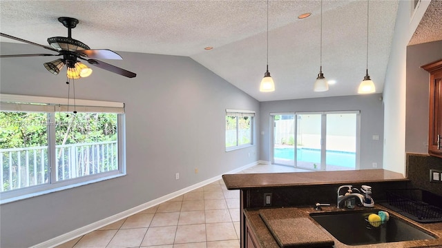 kitchen with lofted ceiling, sink, ceiling fan, a textured ceiling, and light tile patterned flooring