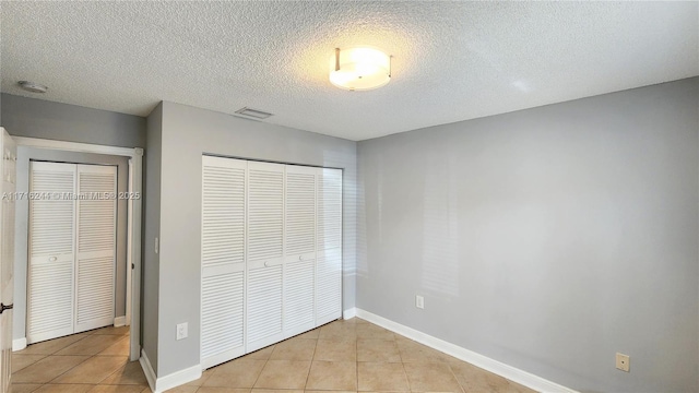 unfurnished bedroom featuring light tile patterned floors and a textured ceiling