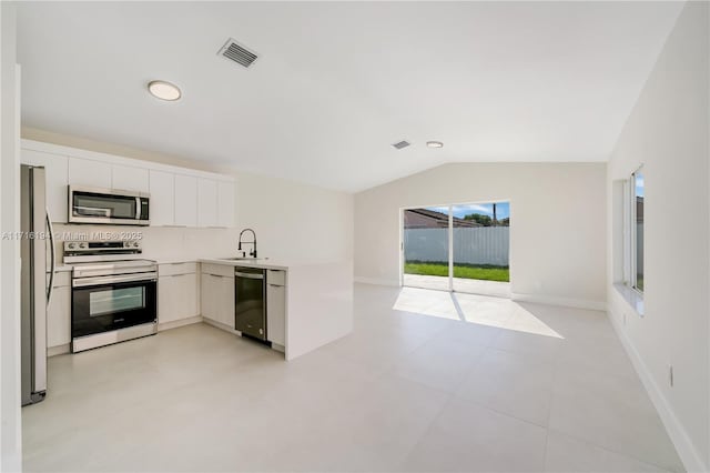 kitchen featuring white cabinetry, lofted ceiling, stainless steel appliances, and a healthy amount of sunlight