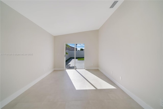 empty room featuring light tile patterned flooring and vaulted ceiling