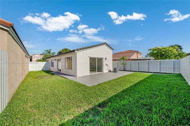 back of house with a lawn, central air condition unit, and a patio area