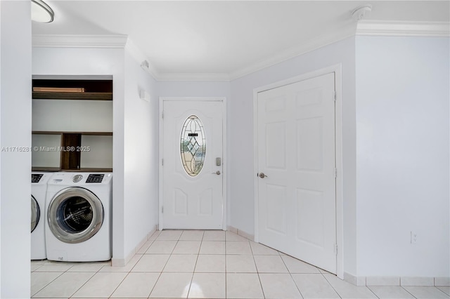 laundry room with light tile patterned floors, ornamental molding, and washing machine and clothes dryer