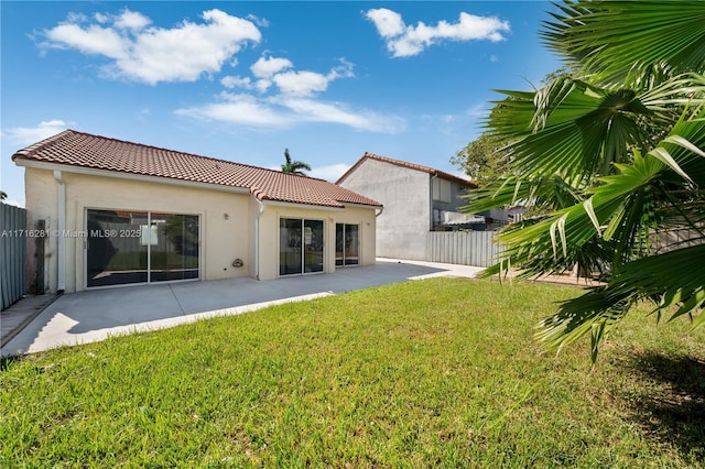 rear view of house with a patio and a lawn