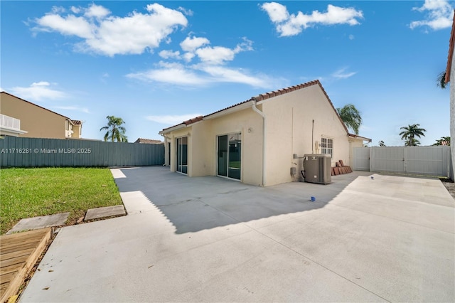 back of house with central AC unit, a yard, and a patio