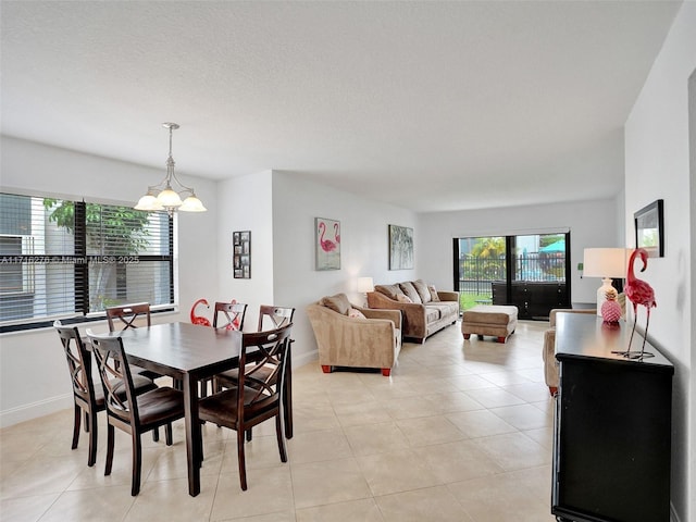 dining area featuring light tile patterned floors, baseboards, and an inviting chandelier