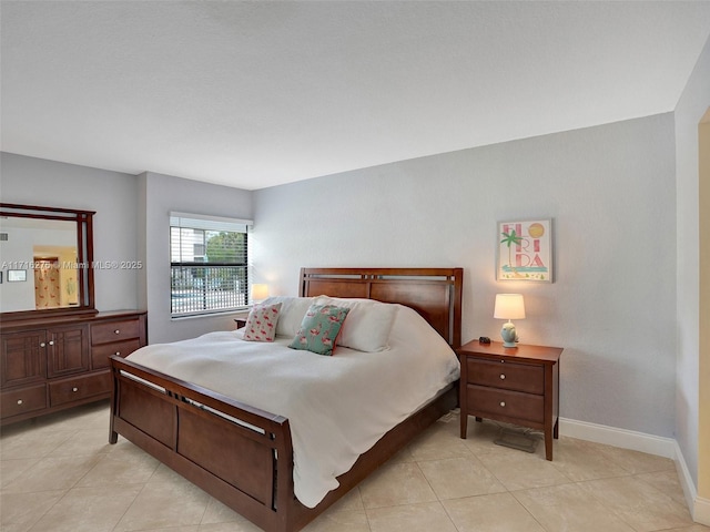 bedroom featuring light tile patterned floors and baseboards