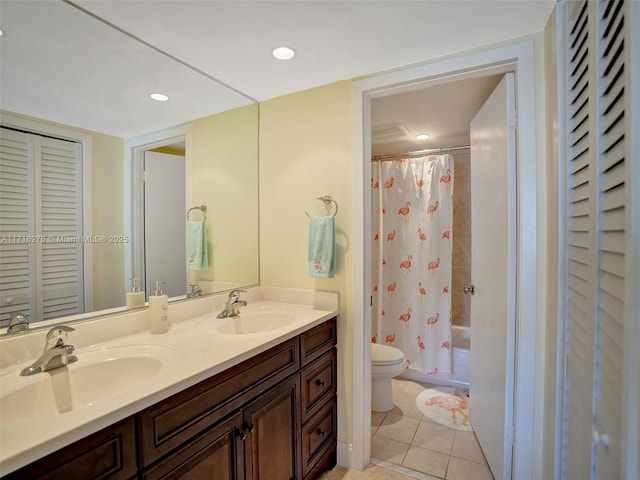 bathroom featuring a sink, tile patterned flooring, toilet, and double vanity