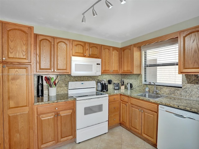 kitchen with light tile patterned floors, a sink, white appliances, backsplash, and light stone counters