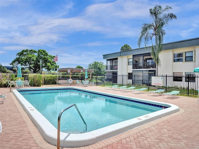 pool featuring a pergola, a patio, and fence