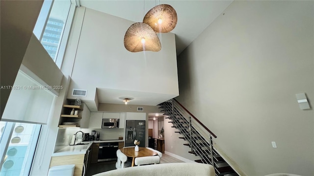 stairway with sink and a towering ceiling