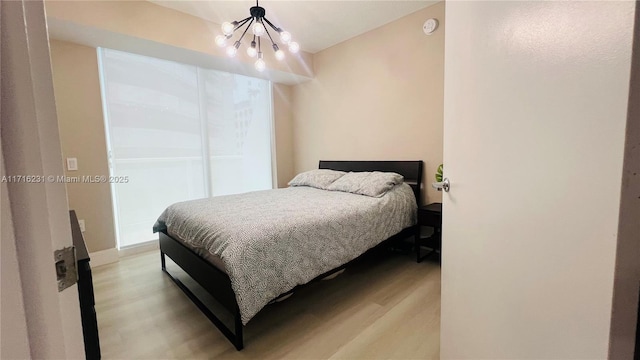 bedroom featuring light hardwood / wood-style floors and an inviting chandelier