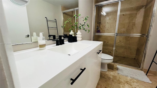 bathroom featuring vanity, a shower with shower door, and toilet