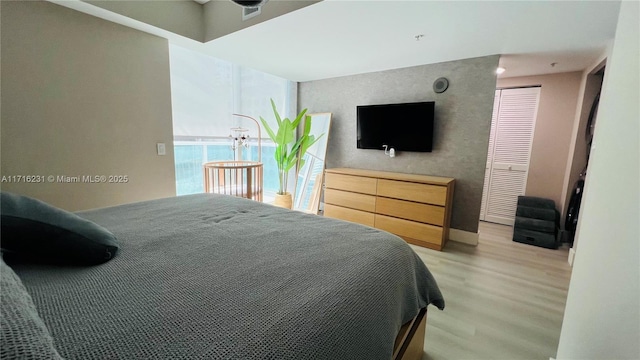 bedroom with light wood-type flooring and a closet