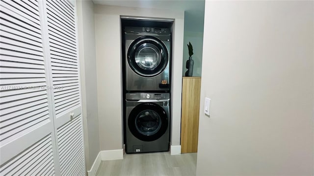 clothes washing area with light hardwood / wood-style floors and stacked washing maching and dryer