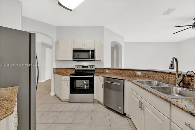 kitchen with white cabinets, a ceiling fan, stainless steel appliances, and a sink