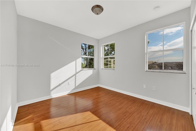 unfurnished room featuring wood finished floors and baseboards