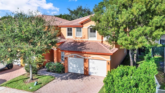 view of front of house with decorative driveway, a tiled roof, and stucco siding