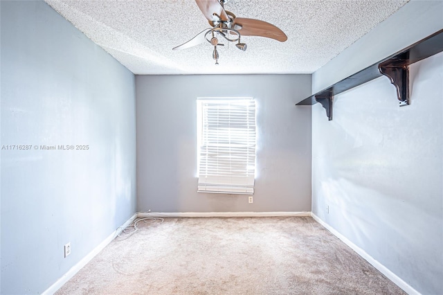 carpeted empty room featuring ceiling fan and a textured ceiling