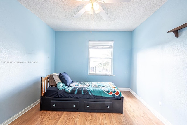 bedroom featuring wood-type flooring, a textured ceiling, and ceiling fan