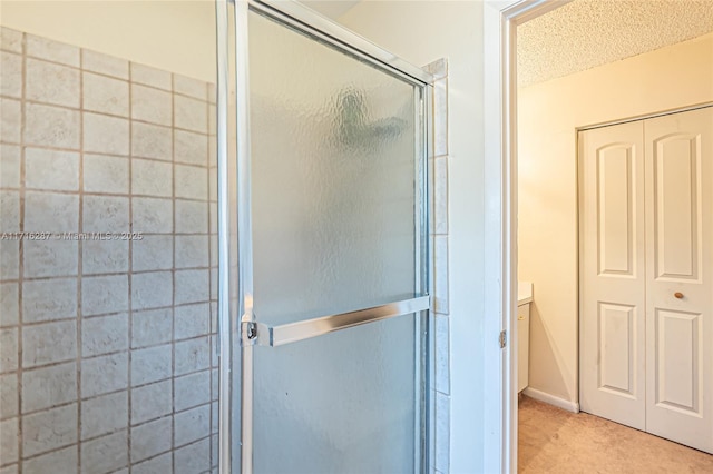 bathroom with vanity, an enclosed shower, and a textured ceiling