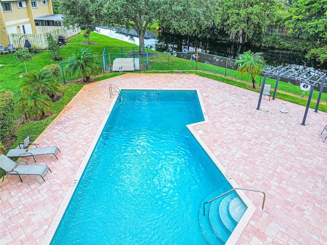 view of pool featuring a yard, a water view, and a patio area