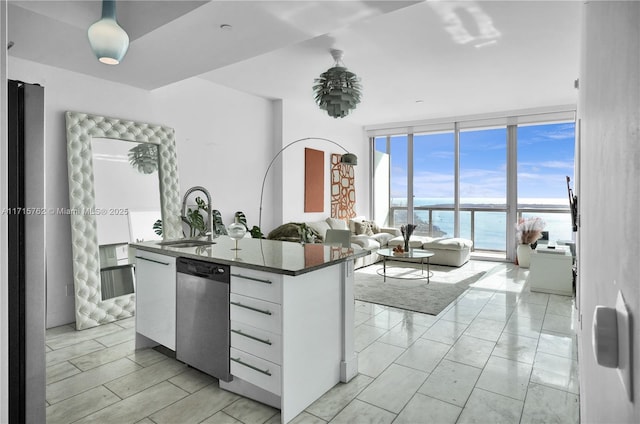 kitchen with stainless steel dishwasher, sink, a water view, a wall of windows, and white cabinets