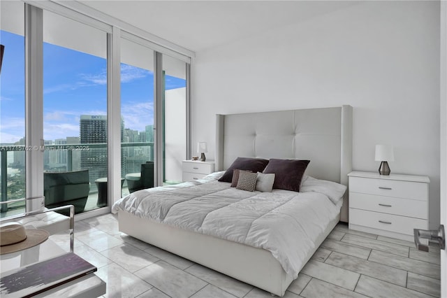 bedroom with access to outside and a wall of windows