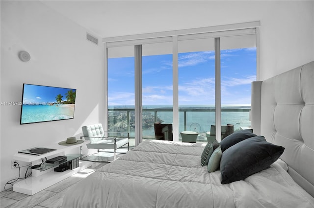 bedroom featuring multiple windows and a water view