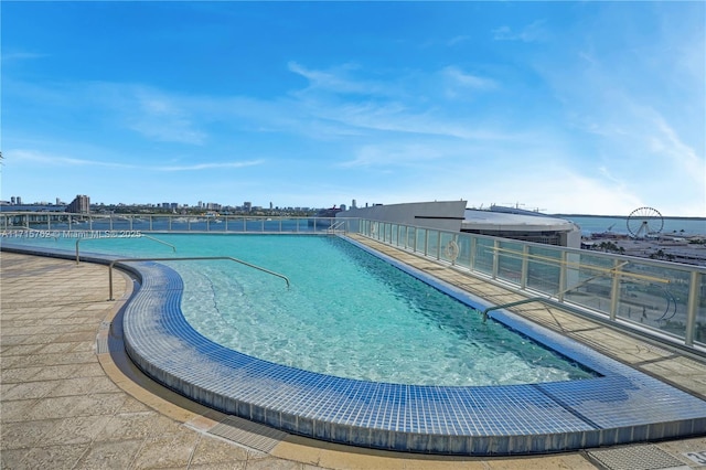 view of pool featuring a patio area and a water view