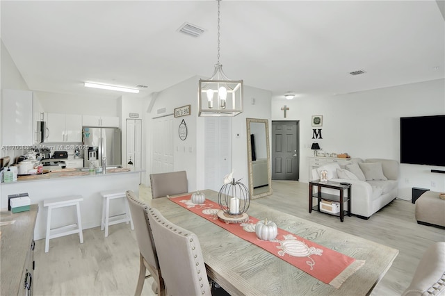 dining room with an inviting chandelier and light hardwood / wood-style flooring