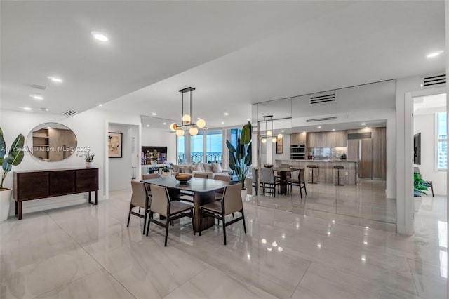 dining space with a chandelier, recessed lighting, marble finish floor, and visible vents